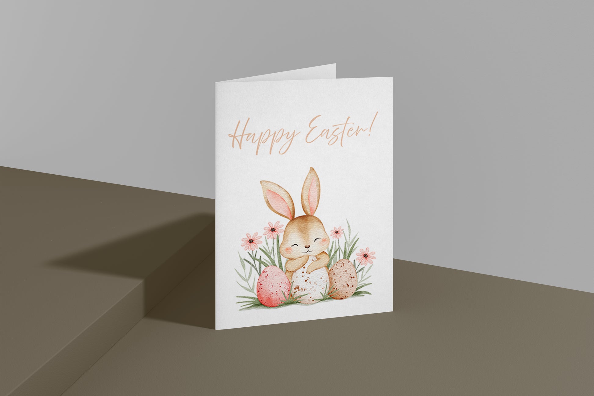 Süße Osterkarte mit einem niedlichen Hasen, der zwischen bunten Ostereiern und Frühlingsblumen sitzt. Aquarell Illustration mit sanften Pastellfarben und dem Schriftzug „Happy Easter“. Perfekt für Ostergrüße an Familie und Freunde.