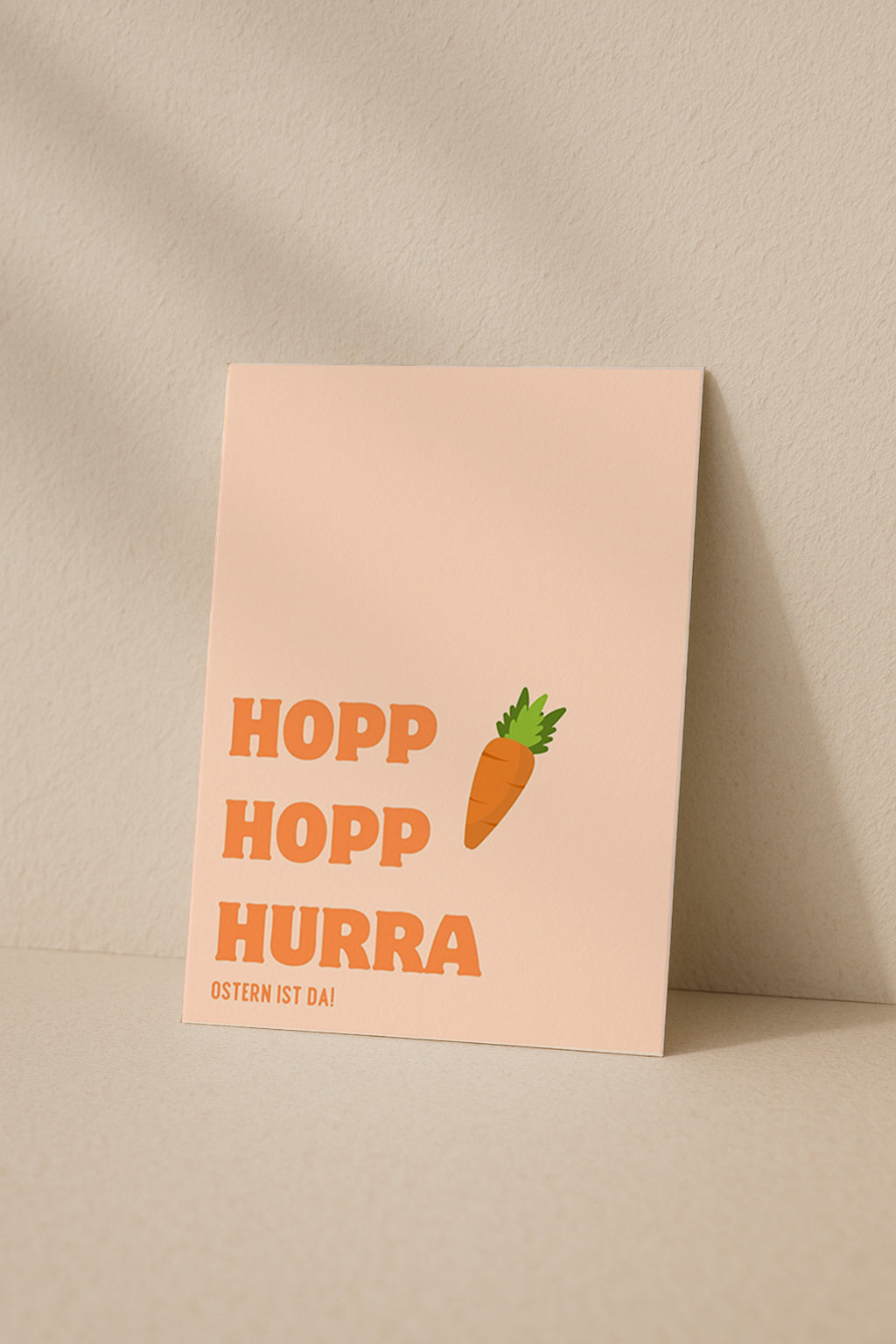 Moderne Osterkarte mit dem Schriftzug „Hopp Hopp Hurra – Ostern ist da“. Minimalistisches Design mit Karotte Illustration und warmen Pastellfarben. Perfekt als humorvolle Osterkarte für Freunde oder Familie.