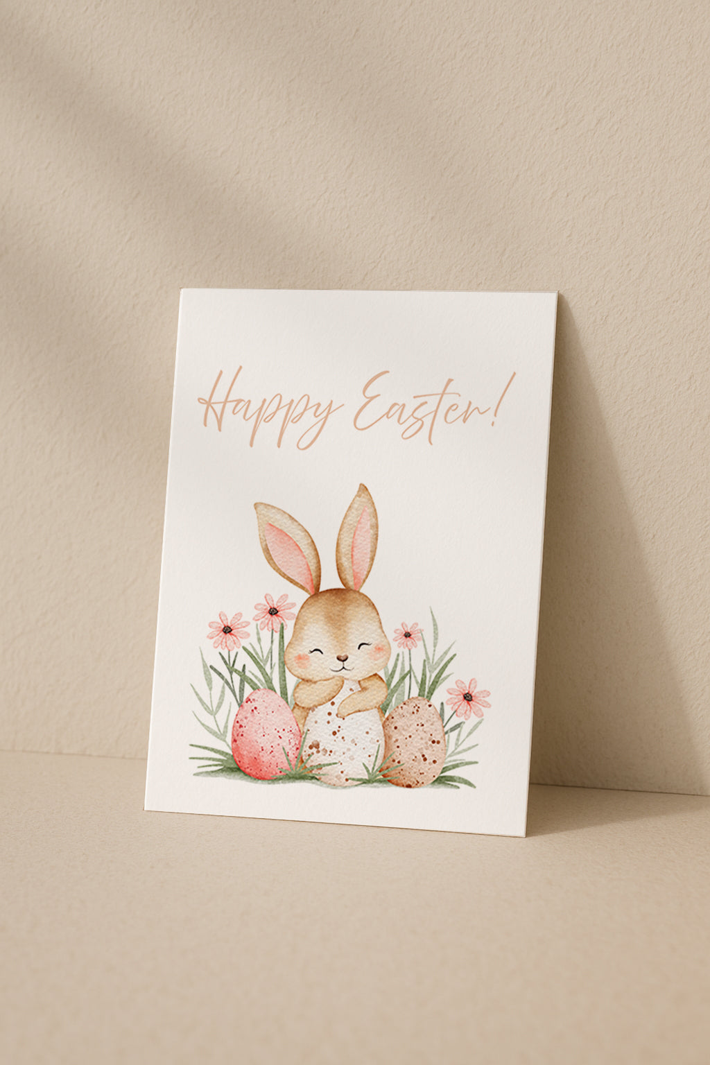 Süße Osterkarte mit einem niedlichen Hasen, der zwischen bunten Ostereiern und Frühlingsblumen sitzt. Aquarell Illustration mit sanften Pastellfarben und dem Schriftzug „Happy Easter“. Perfekt für Ostergrüße an Familie und Freunde.