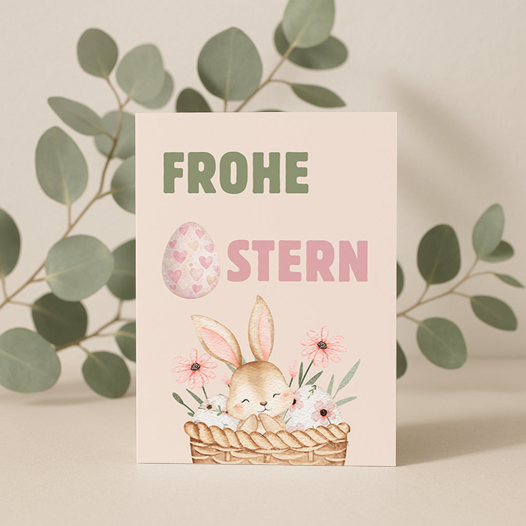 Niedliche Osterkarte mit einem kleinen Hasen in einem Korb mit Blumen und Ostereiern. Aquarell Illustration mit Pastellfarben und dem Schriftzug „Frohe Ostern“. Perfekt als Oster Grußkarte für Familie und Freunde.