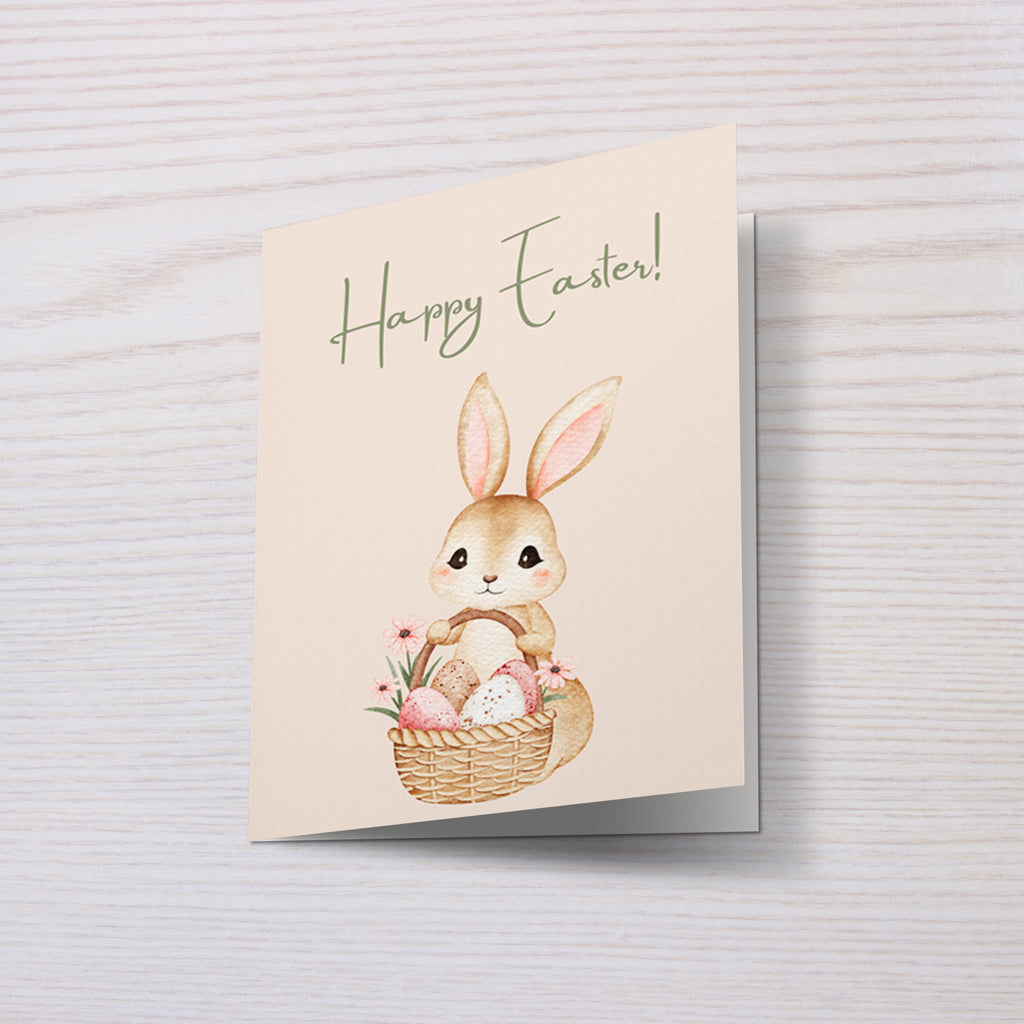 Niedliche Osterkarte mit einem kleinen Hasen, der einen Korb mit bunten Ostereiern hält. Aquarell Stil Illustration mit Blumen und sanften Frühlingsfarben. Oben steht „Happy Easter“. Perfekt als Oster Grußkarte für Familie, Freunde oder Kinder.
