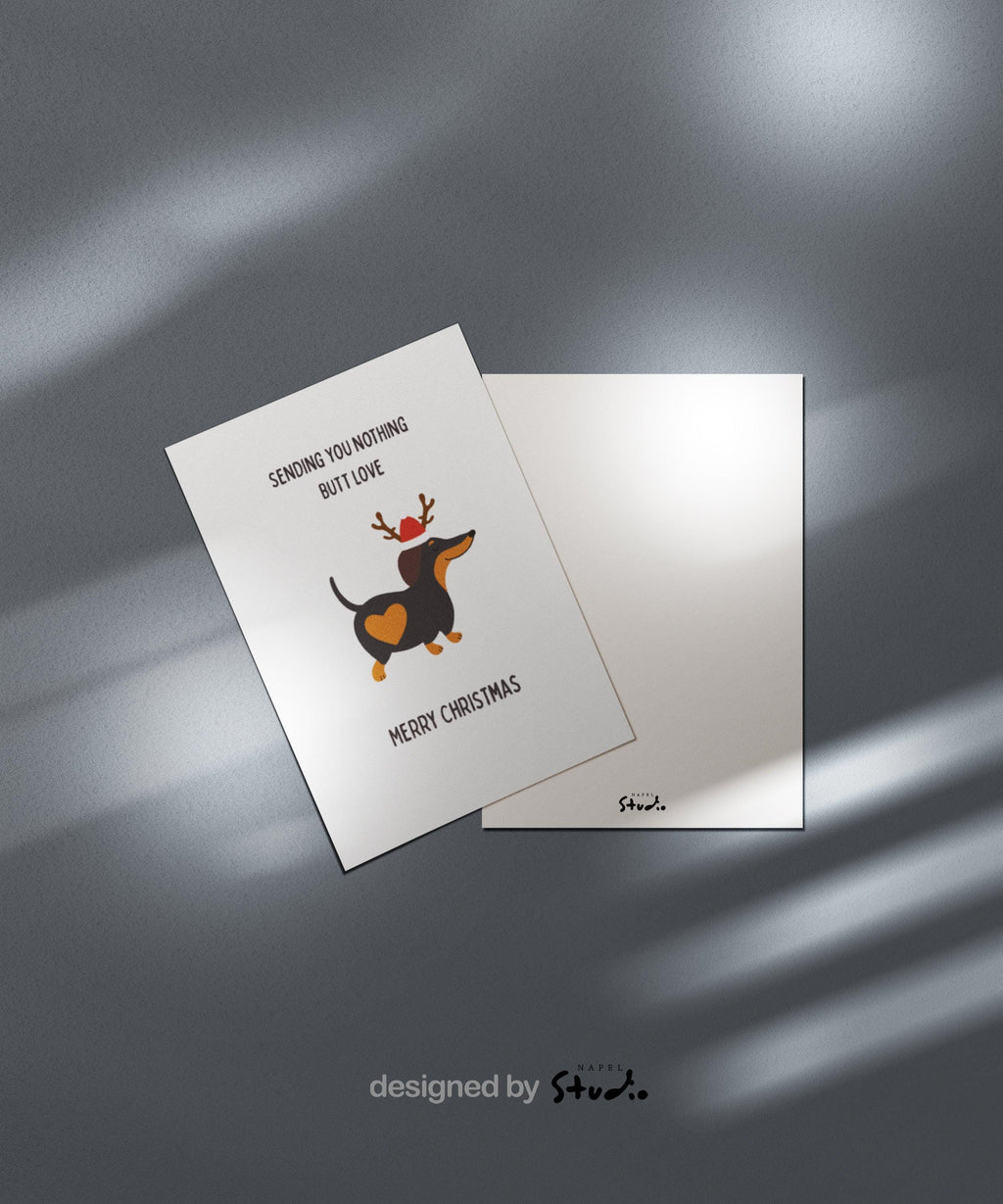 Diese witzige Weihnachtskarte zeigt einen Dackel mit einem großen Herzfleck auf dem Po, einem Rentiergeweih und einer kleinen Weihnachtsmütze. Darüber steht der Spruch „Sending you nothing butt love“, darunter „Merry Christmas“. Das Motiv ist humorvoll, süß und perfekt für Hundeliebhaber, Dackelfans oder als origineller Weihnachtsgruß für Freunde, Familie oder Haustierbesitzer.