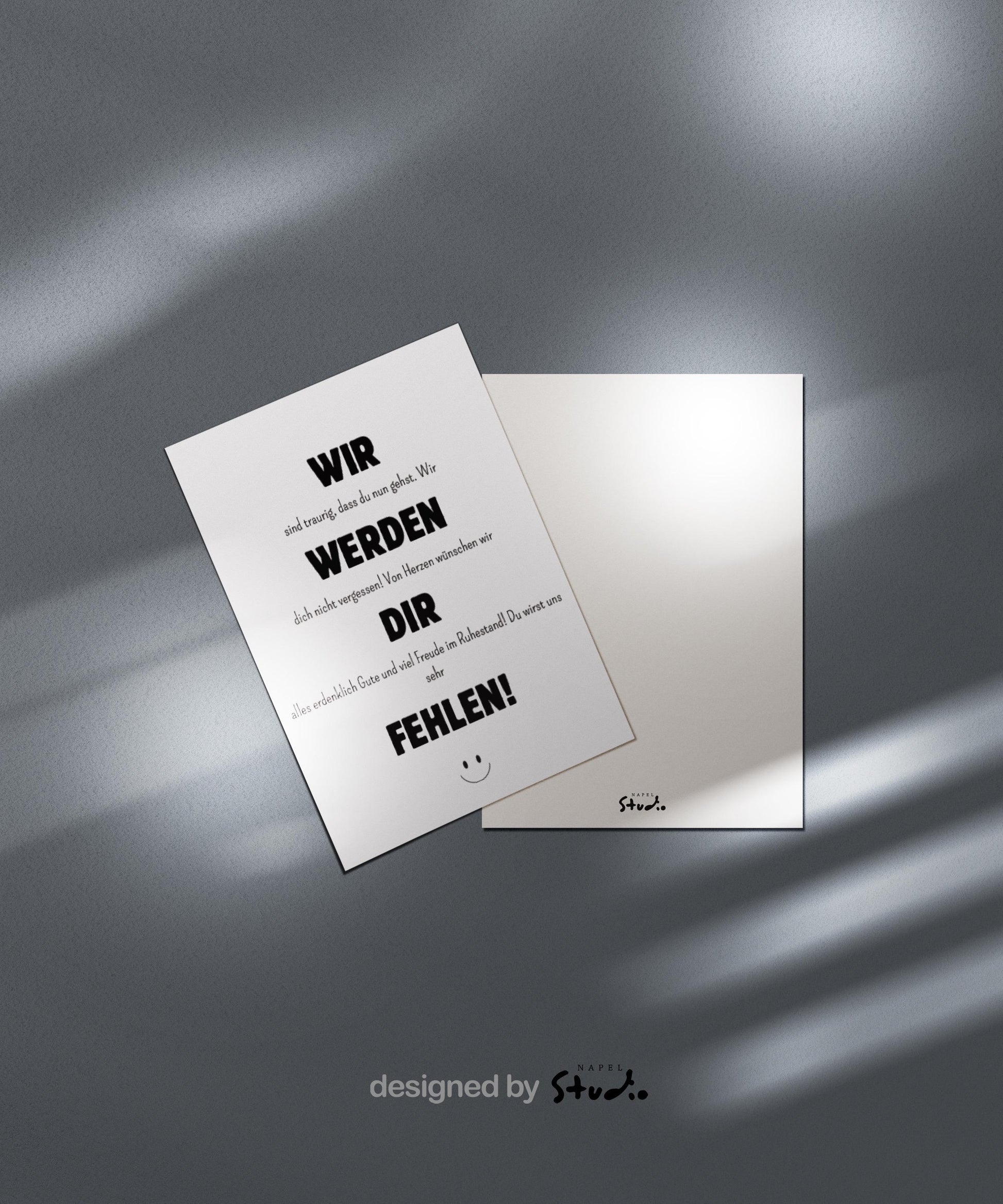 Weiße Abschiedskarte mit schwarzer Typografie und dem Text „Wir werden dir fehlen“. Minimalistisches, modernes Design mit kleinem Smiley unten. Die Karte liegt auf einem braunen Umschlag. Ideal für Kollegen zum Ruhestand oder Abschied im Job. Perfekt als liebevolle Wertschätzung am letzten Arbeitstag.