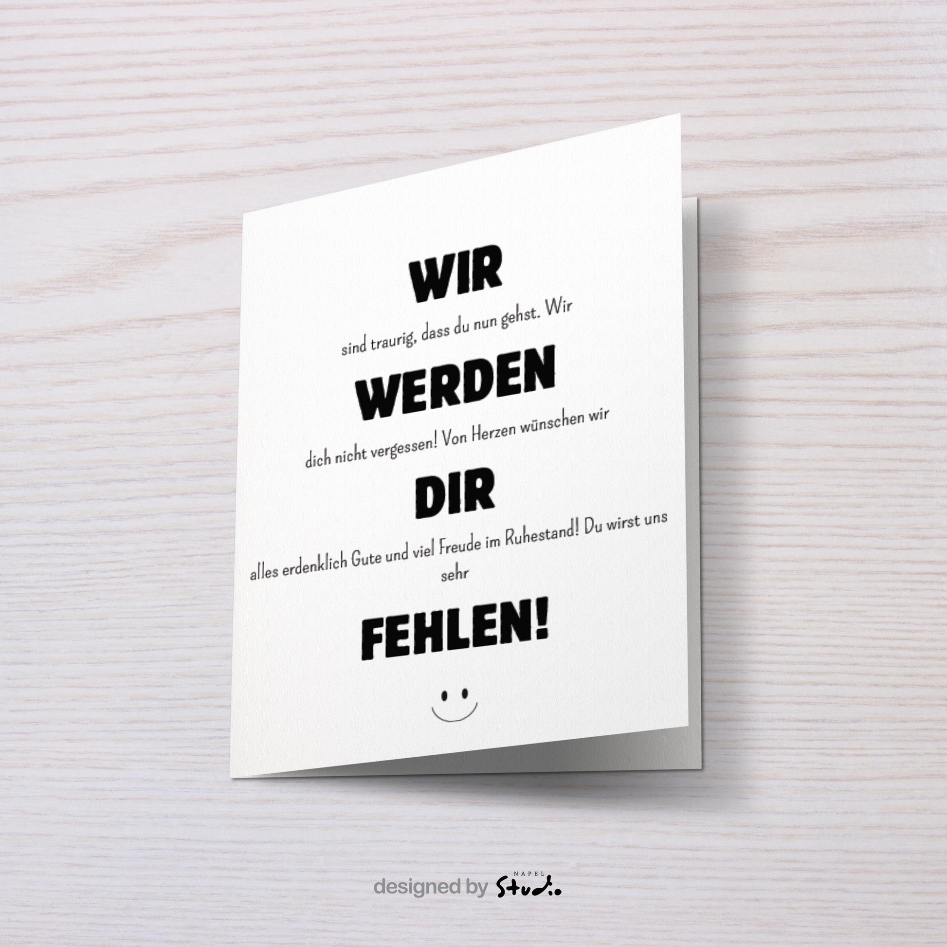 Weiße Abschiedskarte mit schwarzer Typografie und dem Text „Wir werden dir fehlen“. Minimalistisches, modernes Design mit kleinem Smiley unten. Die Karte liegt auf einem braunen Umschlag. Ideal für Kollegen zum Ruhestand oder Abschied im Job. Perfekt als liebevolle Wertschätzung am letzten Arbeitstag.