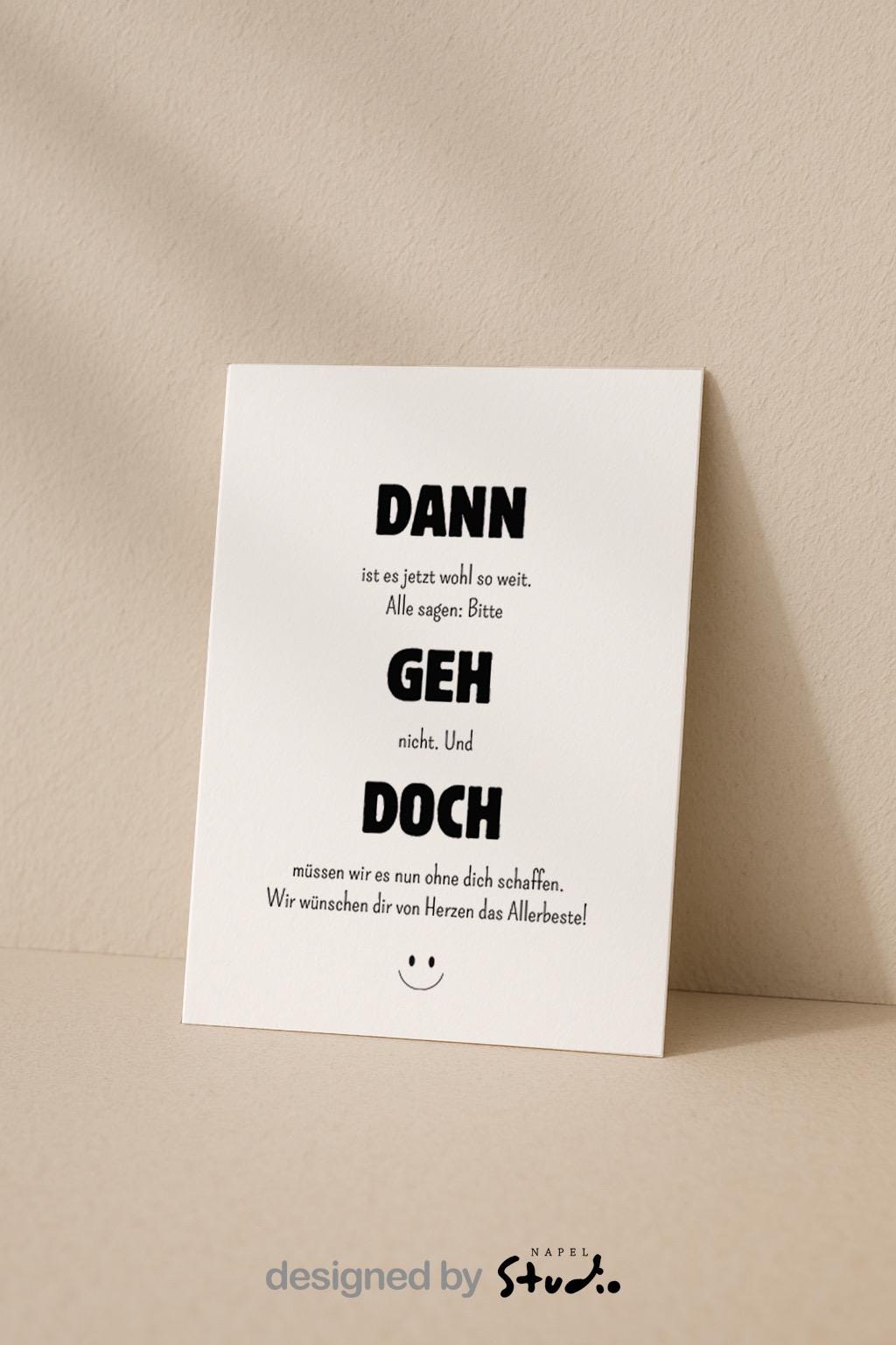 Weiße Abschiedskarte mit dem Spruch „Dann geh doch“ in großer, schwarzer Typografie. Dazwischen kleinerer Text im minimalistischen Stil. Humorvolle, moderne Gestaltung mit kleinem Smiley unten. Karte liegt auf einem hellbraunen Umschlag. Ideal für Kollegen, die das Team verlassen oder den Job wechseln.