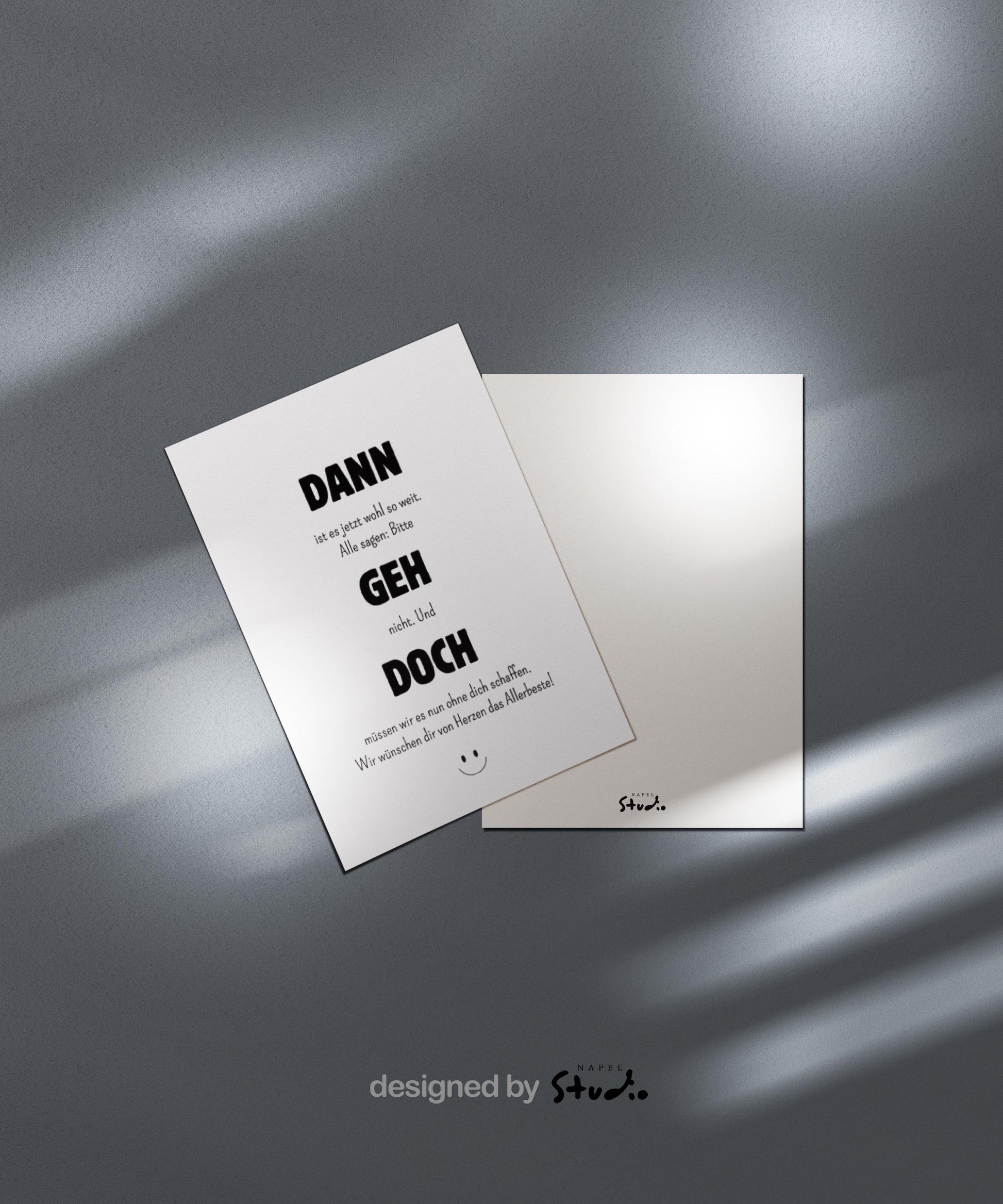 Weiße Abschiedskarte mit dem Spruch „Dann geh doch“ in großer, schwarzer Typografie. Dazwischen kleinerer Text im minimalistischen Stil. Humorvolle, moderne Gestaltung mit kleinem Smiley unten. Karte liegt auf einem hellbraunen Umschlag. Ideal für Kollegen, die das Team verlassen oder den Job wechseln.