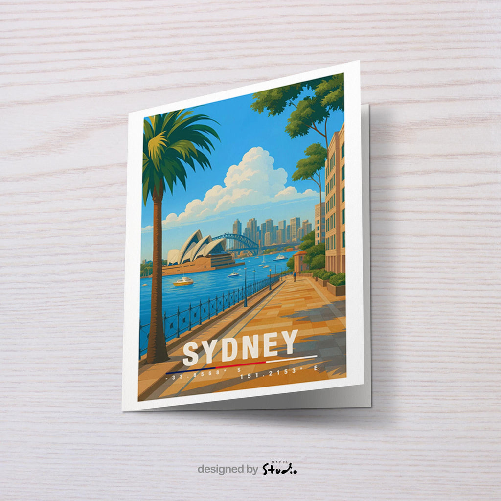 A6-Grußkarte mit Sydney-Illustration: Blick entlang einer palmengesäumten Promenade auf das Opera House und die Harbour Bridge, dahinter die Skyline am Wasser. Boote im Hafen, heller Himmel und klare Farben im modernen Travel-Poster-Stil. Ideal als Reise- oder Souvenirkarte für Sydney- und Australien-Liebhaber.