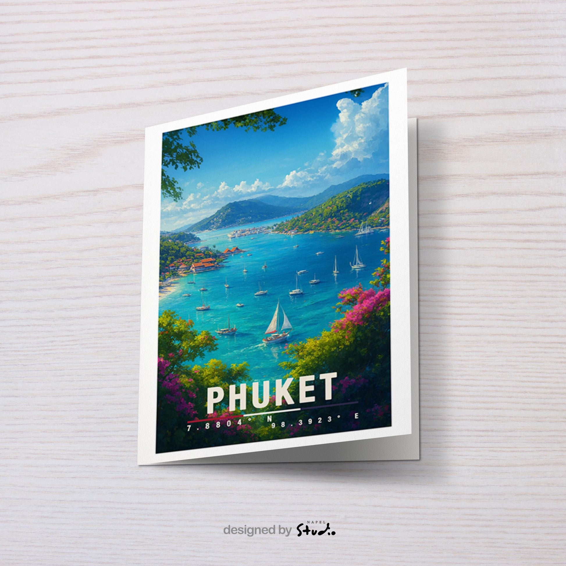 A6-Grußkarte mit Phuket-Illustration: Blick auf eine tropische Bucht mit türkisblauem Meer, zahlreichen Segelbooten und grünen Inselhügeln. Bunte Blumen und Bäume rahmen die Szene ein, im Hintergrund liegen Küste und Dörfer. Heller Himmel mit Wolken, moderner Travel-Poster-Stil, ideal als Reise- oder Souvenirkarte für Thailand- und Insel-Liebhaber.