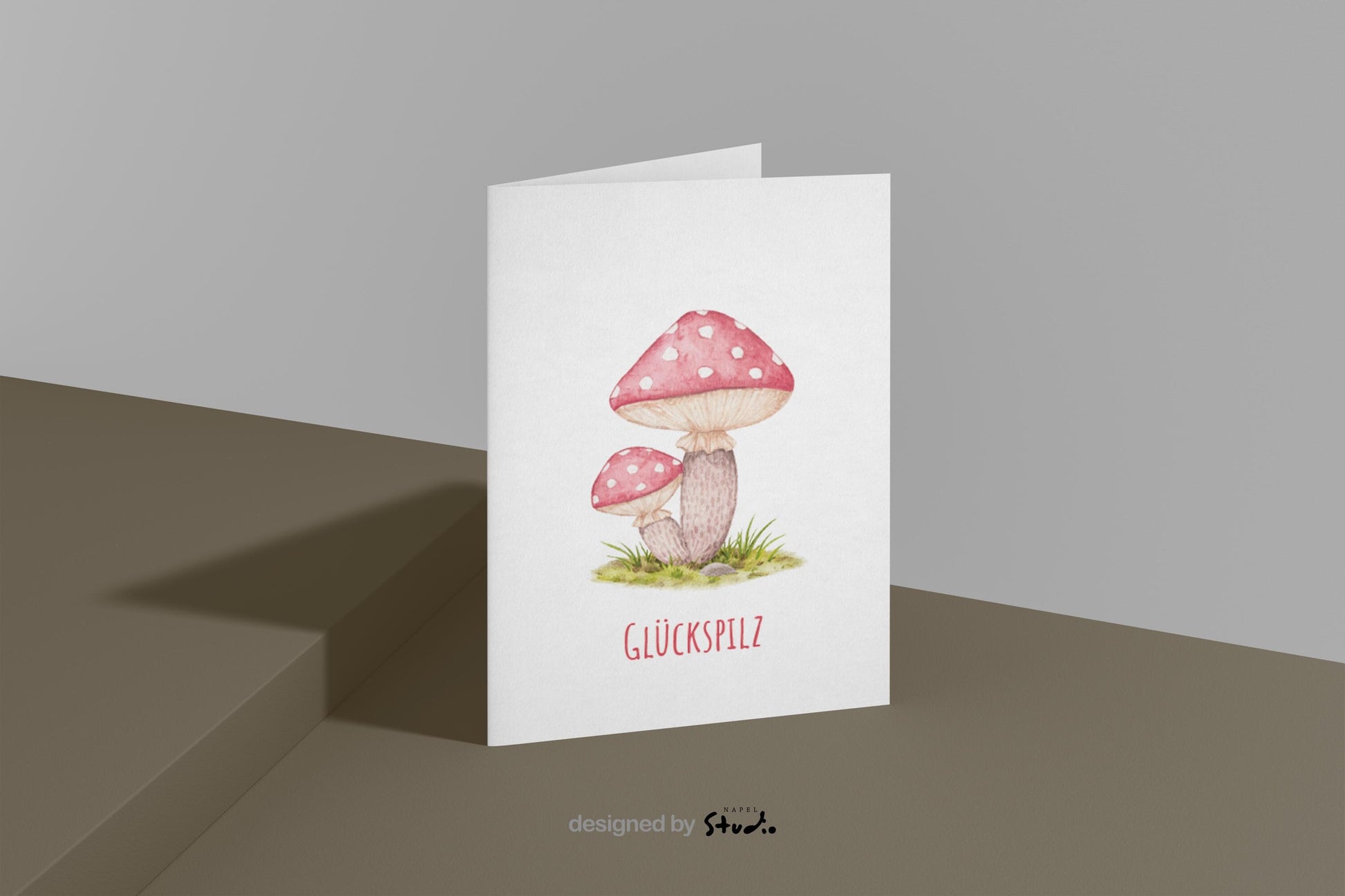 Aquarell-Illustration von zwei roten Fliegenpilzen mit weißen Punkten auf einer grünen Wiese. Darunter steht der Schriftzug „Glückspilz“. Die Karte vermittelt Glück, Wärme und Naturverbundenheit und eignet sich perfekt als Geburtstagskarte, Glückwunschkarte oder kleine Aufmerksamkeit für liebe Menschen.