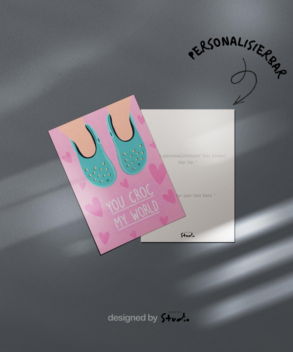 Verspielte Illustration von türkisfarbenen Crocs vor rosafarbenem Hintergrund mit kleinen Herzmotiven. Der Text „You croc my world“ nutzt ein humorvolles Wortspiel und macht die Karte liebevoll und witzig zugleich. Ideal als Valentinstagskarte, Jahrestagskarte oder als lustige Liebeskarte für Partner, Freunde oder Crocs-Fans.