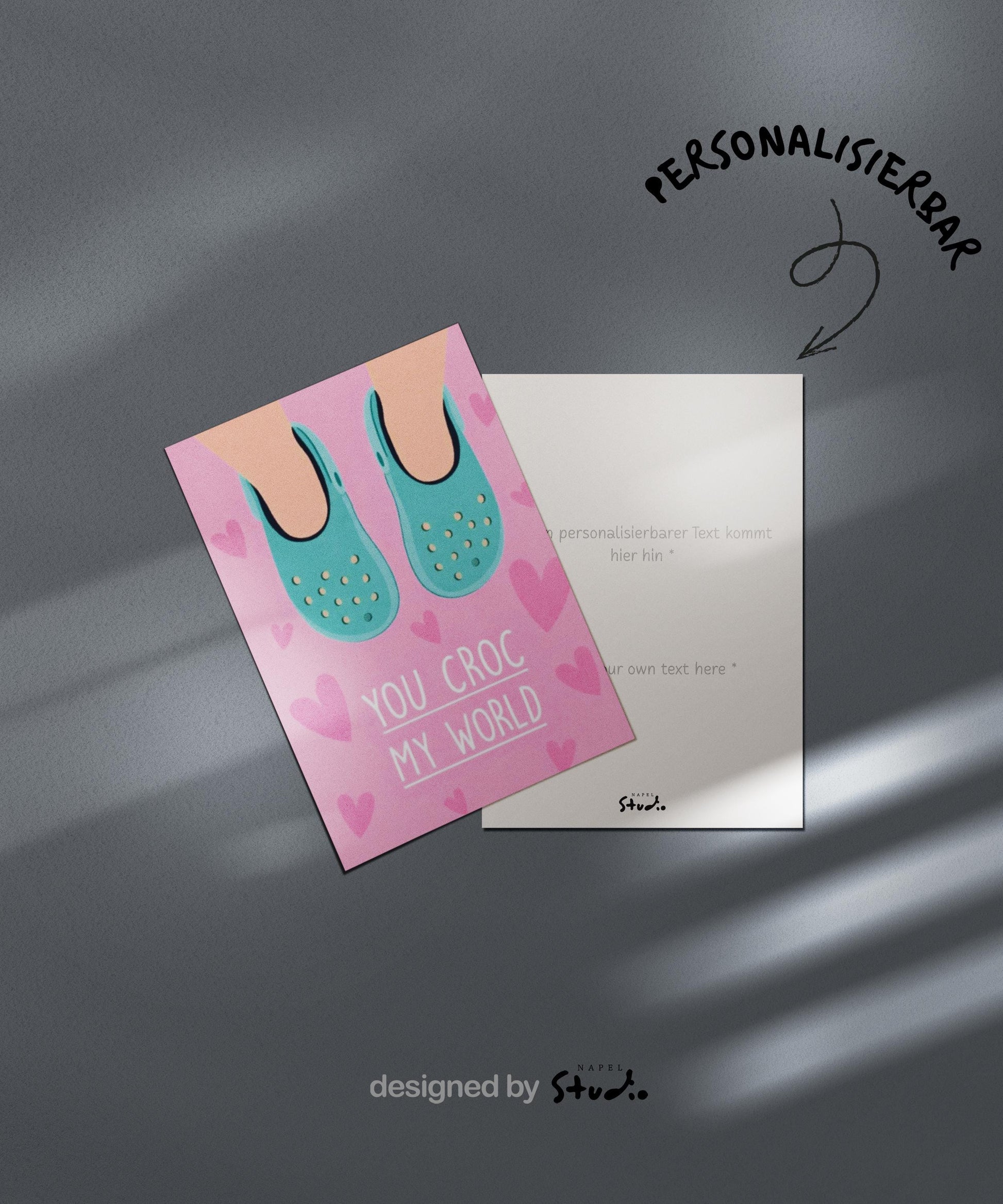 Verspielte Illustration von türkisfarbenen Crocs vor rosafarbenem Hintergrund mit kleinen Herzmotiven. Der Text „You croc my world“ nutzt ein humorvolles Wortspiel und macht die Karte liebevoll und witzig zugleich. Ideal als Valentinstagskarte, Jahrestagskarte oder als lustige Liebeskarte für Partner, Freunde oder Crocs-Fans.