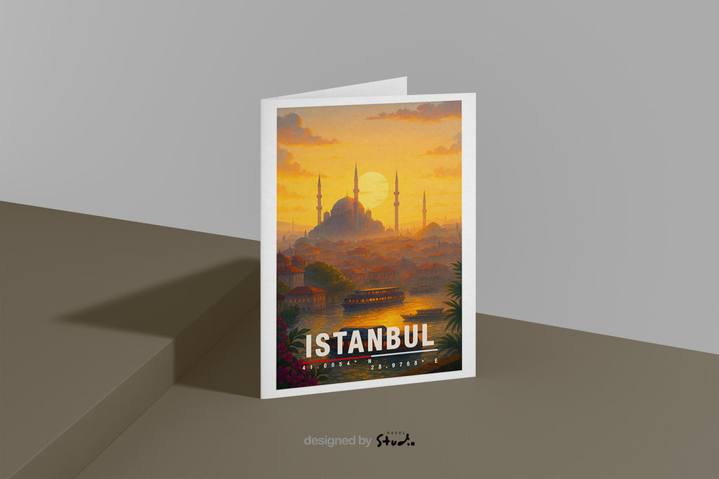 A6 Grußkarte mit Istanbul-Illustration bei warmem Sonnenuntergang. Im Vordergrund Wasser mit Booten, dahinter Häuser und die Silhouette einer großen Moschee mit Minaretten. Unten steht „Istanbul“ mit Koordinaten. Stimmungsvolle Reisekarte als Geschenk für Türkei-Fans.