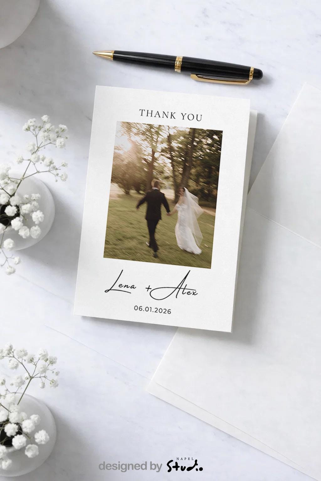 Personalisierte Hochzeits-Dankeskarte im minimalistischen Design mit Hochzeitsfoto eines Brautpaares, das Hand in Hand durch einen Park läuft. Über dem Foto steht „Thank You“, darunter die handschriftlichen Namen Lena + Alex sowie das Hochzeitsdatum. Moderne, elegante Hochzeitspapeterie in neutralen Farben, ideal als Dankeskarte nach der Hochzeit.