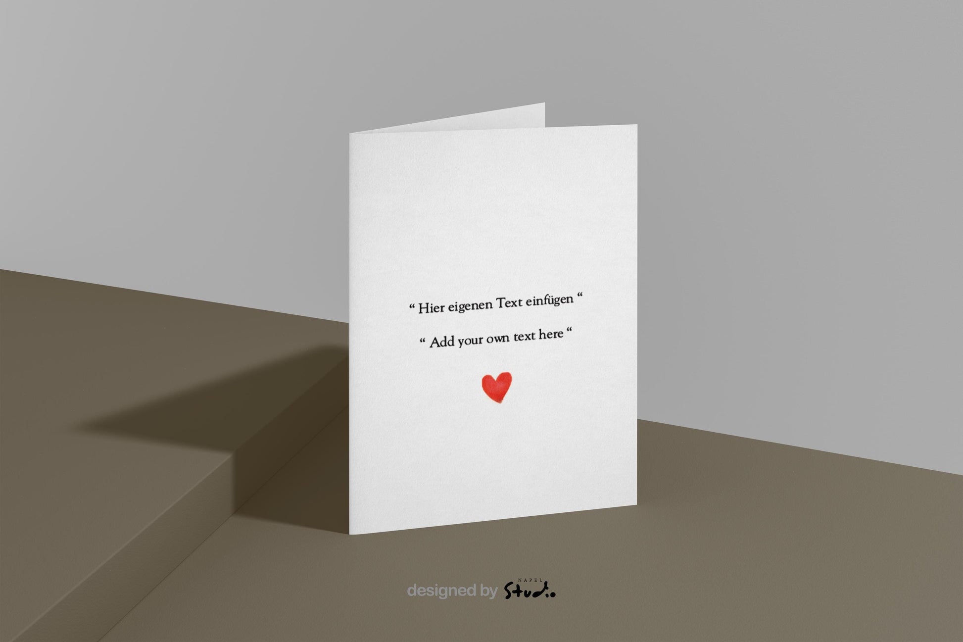 Schlichte, minimalistische Grußkarte mit weißem Hintergrund und zentriertem Text. In der Mitte steht der Hinweis „Hier eigenen Text einfügen“ sowie darunter „Add your own text here“, was die Personalisierung der Karte hervorhebt. Unter dem Text befindet sich ein kleines rotes Herz als liebevolles Detail. Das Design wirkt modern, zeitlos und emotional und eignet sich ideal als personalisierbare Grußkarte für Geburtstage, Hochzeiten, Jahrestage, Valentinstag oder besondere persönliche Anlässe.