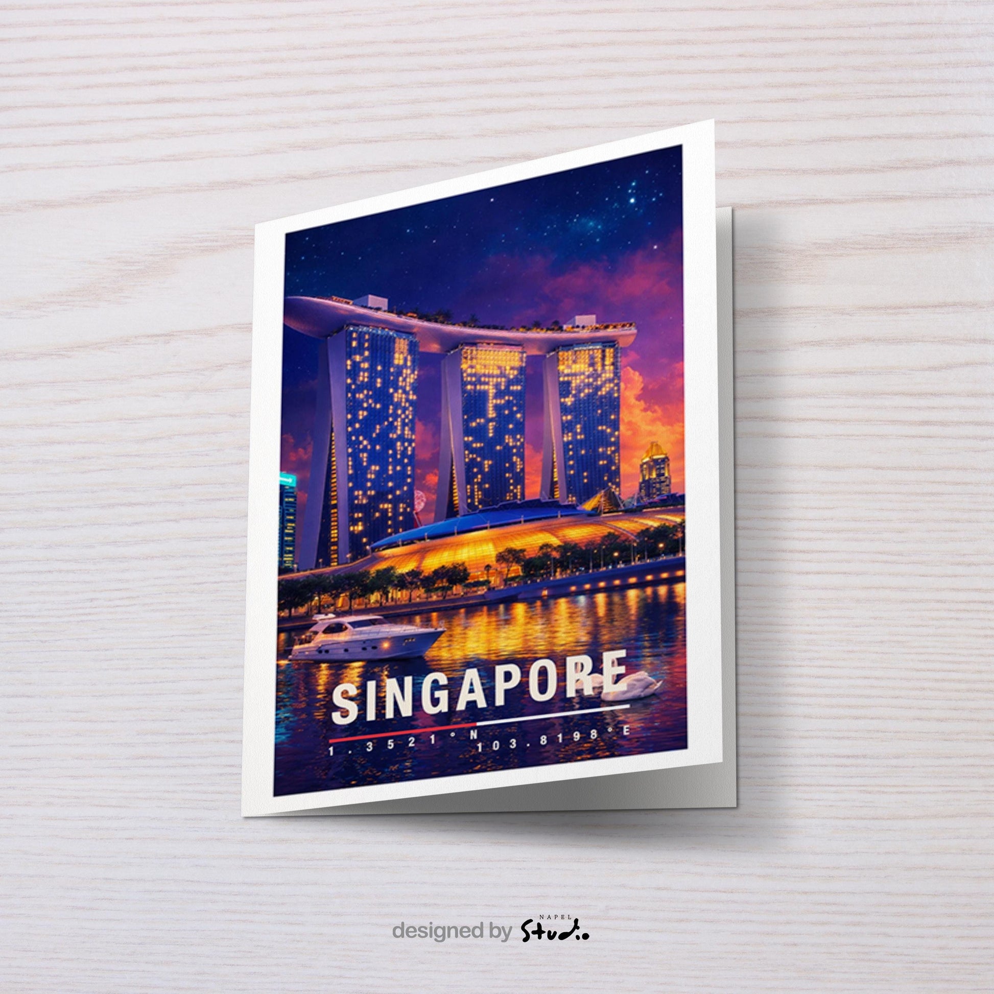 Moderne Grußkarte mit nächtlichem Singapore-Motiv, zeigt die leuchtende Skyline und das ikonische Marina-Bay-Gebäude mit Spiegelungen im Wasser. Die Illustration vermittelt urbanen Luxus, asiatische Metropole und Reisefieber. Ideal als Reise-Grußkarte, Urlaubsgruß oder stilvolle Nachricht für Singapore-Fans, Weltenbummler und Liebhaber moderner Städte.