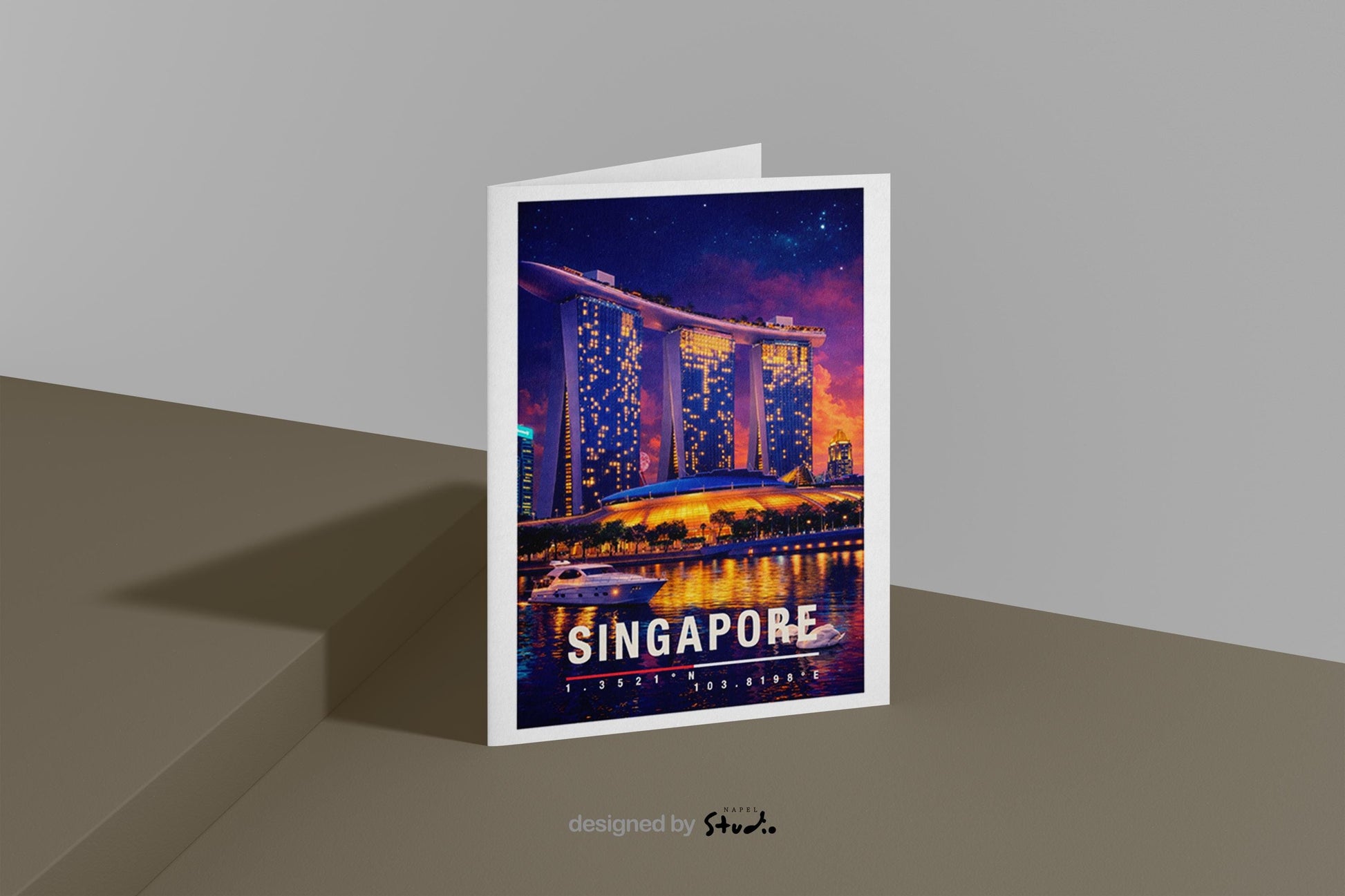 Moderne Grußkarte mit nächtlichem Singapore-Motiv, zeigt die leuchtende Skyline und das ikonische Marina-Bay-Gebäude mit Spiegelungen im Wasser. Die Illustration vermittelt urbanen Luxus, asiatische Metropole und Reisefieber. Ideal als Reise-Grußkarte, Urlaubsgruß oder stilvolle Nachricht für Singapore-Fans, Weltenbummler und Liebhaber moderner Städte.