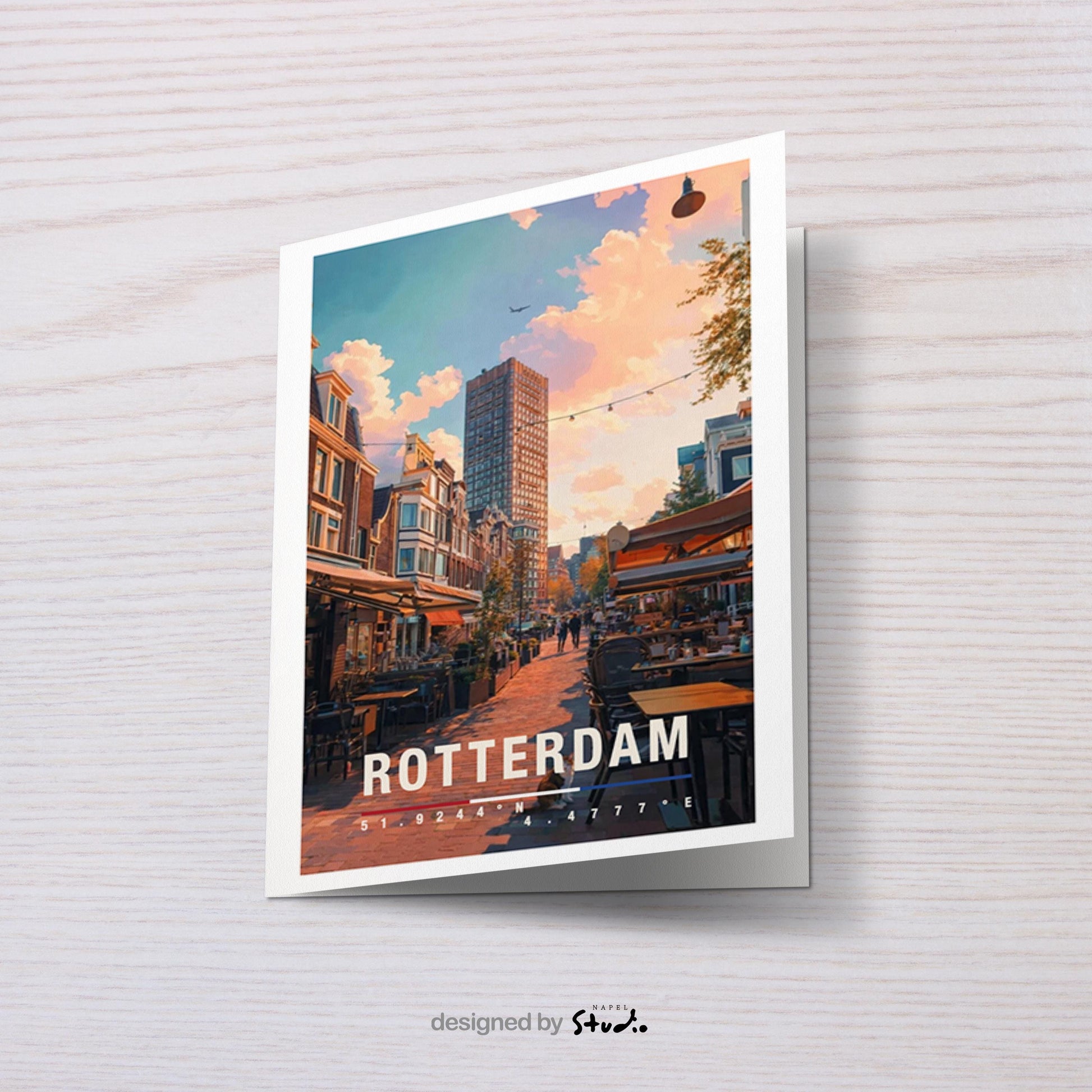 Illustrative Grußkarte mit einer warmen Straßenszene in Rotterdam, Niederlande. Zu sehen sind gemütliche Cafés mit Außentischen, typische niederländische Häuserfassaden und ein moderner Hochhausbau im Hintergrund. Die Abendstimmung mit weichem Licht vermittelt urbanes Flair, Reisegefühl und europäische Stadtromantik. Ideal als Städtegruß, Reisekarte oder Erinnerung an Rotterdam.