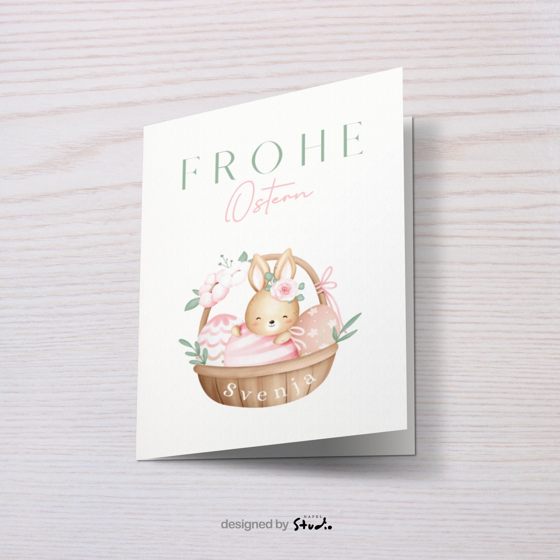 Personalisierte Oster Grußkarte mit niedlichem Hasen im Körbchen und dekorativen Ostereiern, sanfte Pastellfarben und verspieltes Design, ideal für Kinder, Familie oder als liebevolle Osterüberraschung, fröhliche Osterkarte mit Platz für individuellen Namen.