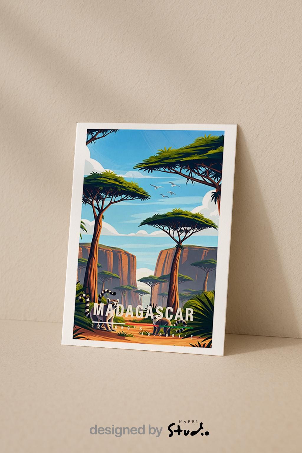 Illustrative Grußkarte mit einer warmen, farbenfrohen Landschaft aus Madagaskar. Im Vordergrund stehen zwei Lemuren auf einem sandfarbenen Pfad, umgeben von üppigem Grün und typischen Pflanzen. Hohe, charakteristische Bäume mit flachen Kronen prägen die Szenerie, während sich im Hintergrund felsige Schluchten und eine weite Naturkulisse unter blauem Himmel mit sanften Wolken erstrecken. Fliegende Vögel verleihen dem Motiv Leichtigkeit und Tiefe. Die Karte vermittelt Abenteuer, Exotik.