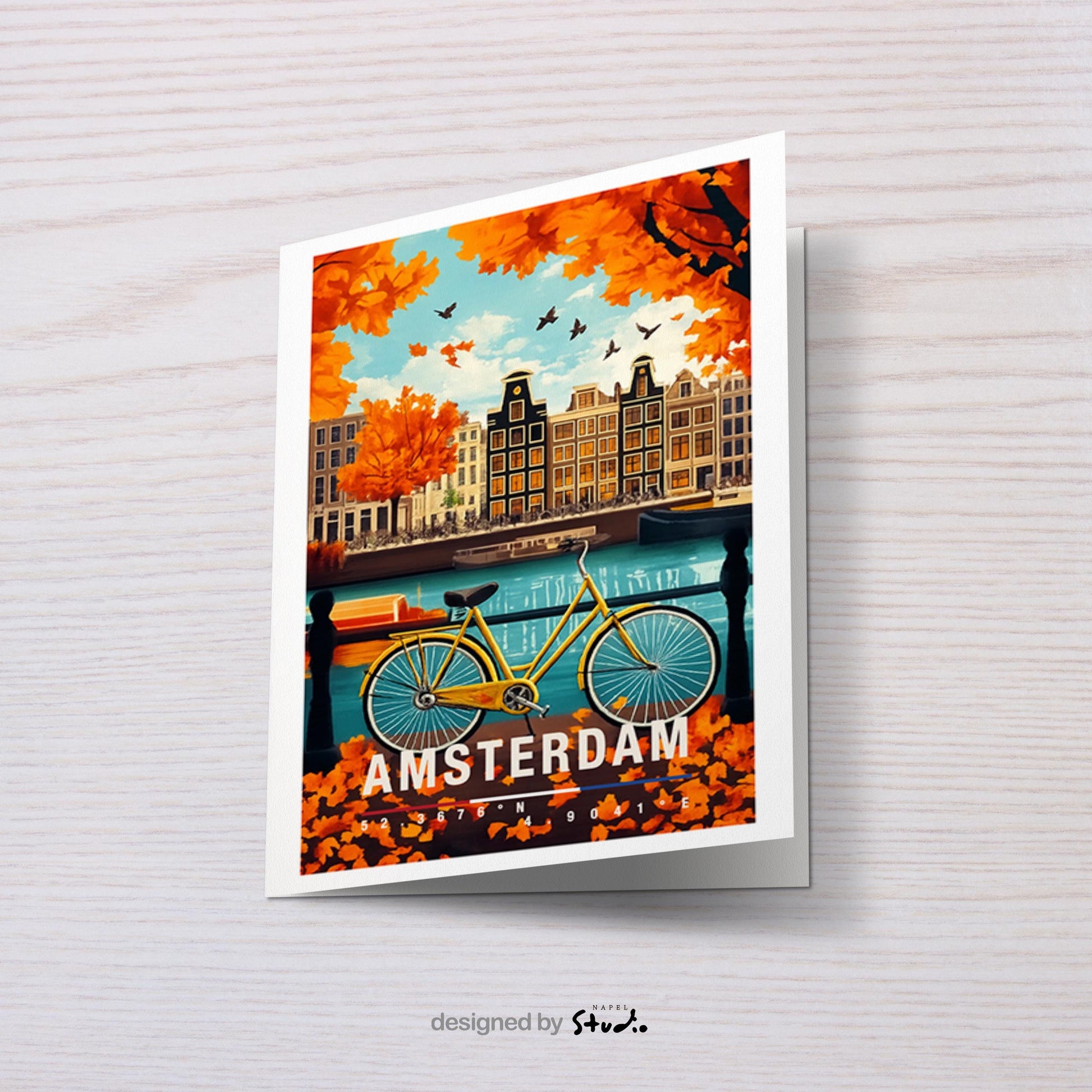 Diese Grußkarte zeigt eine herbstliche Szene in Amsterdam mit bunten Blättern, typischen Grachtenhäusern und einem Fahrrad am Wasser. Die warme Farbpalette vermittelt Gemütlichkeit, Nostalgie und typisches Amsterdam-Flair – perfekt als Reisekarte oder liebevoller Städtegruß.