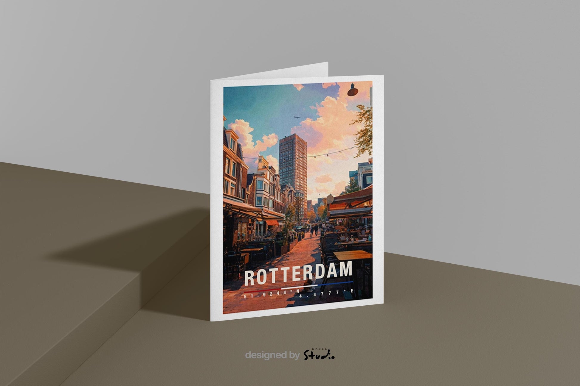 Illustrative Grußkarte mit einer warmen Straßenszene in Rotterdam, Niederlande. Zu sehen sind gemütliche Cafés mit Außentischen, typische niederländische Häuserfassaden und ein moderner Hochhausbau im Hintergrund. Die Abendstimmung mit weichem Licht vermittelt urbanes Flair, Reisegefühl und europäische Stadtromantik. Ideal als Städtegruß, Reisekarte oder Erinnerung an Rotterdam.