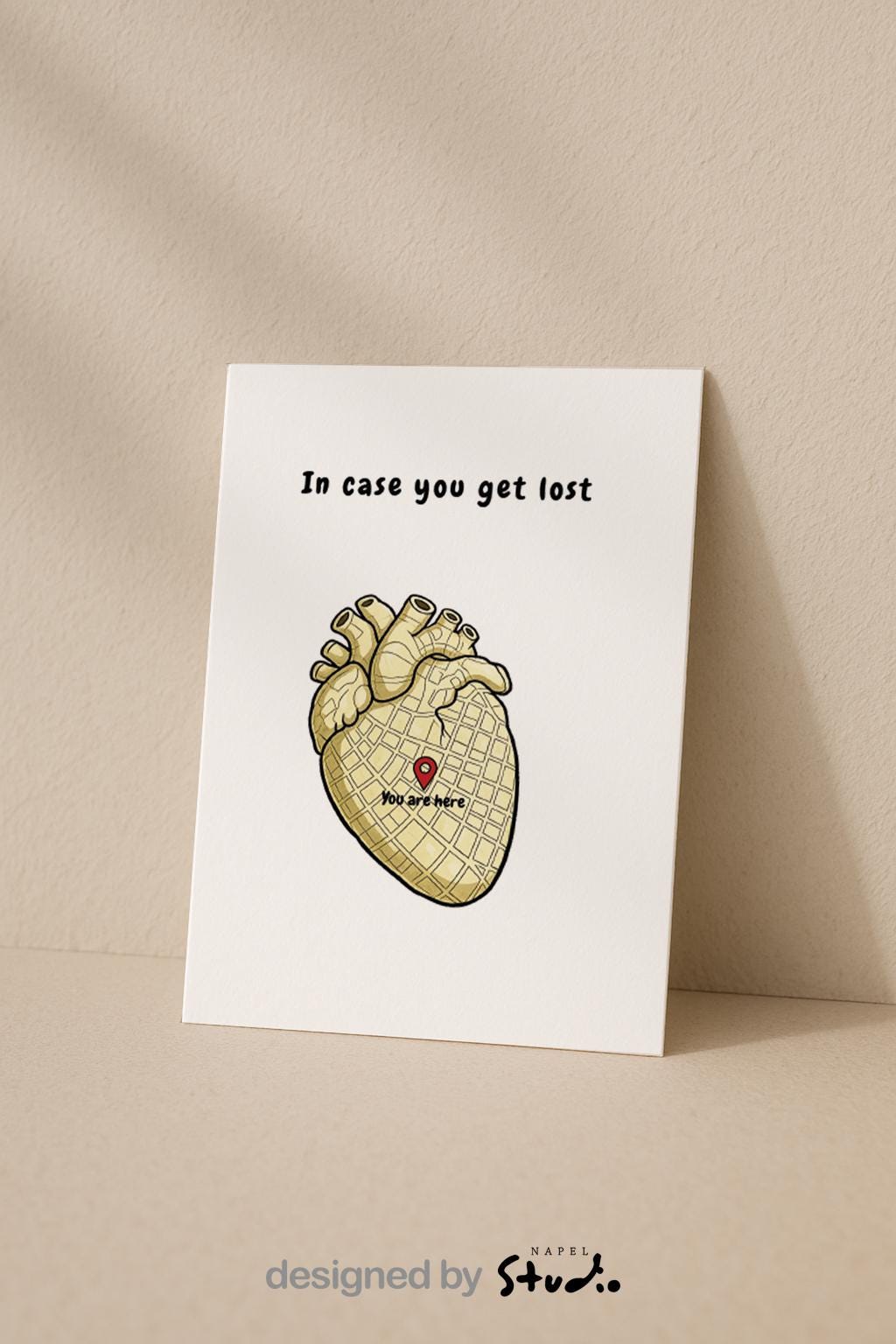 Illustration eines anatomischen Herzens, das wie eine Stadtkarte gestaltet ist. In der Mitte befindet sich ein roter Standort-Pin mit dem Text „You are here“. Darüber steht der Schriftzug „In case you get lost“. Die Karte verbindet Humor, Anatomie und Liebe und eignet sich perfekt als besondere Grußkarte für Partner, Freunde oder als kleine Aufmerksamkeit.