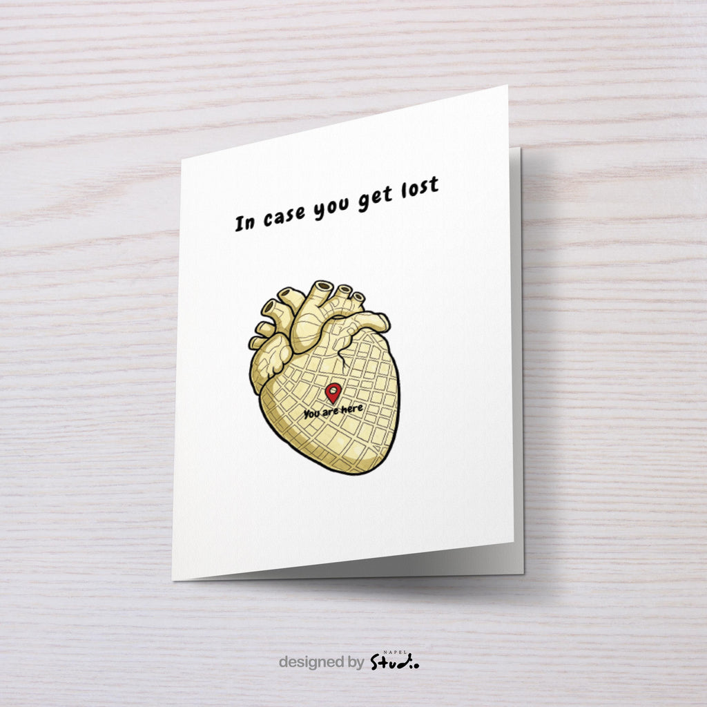 Illustration eines anatomischen Herzens, das wie eine Stadtkarte gestaltet ist. In der Mitte befindet sich ein roter Standort-Pin mit dem Text „You are here“. Darüber steht der Schriftzug „In case you get lost“. Die Karte verbindet Humor, Anatomie und Liebe und eignet sich perfekt als besondere Grußkarte für Partner, Freunde oder als kleine Aufmerksamkeit.