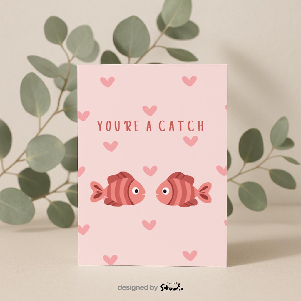 Illustration von zwei Fischen, die sich gegenüberstehen, umgeben von kleinen Herzen. Der Text „You’re a catch“ macht die Karte zu einer charmanten Liebeskarte mit Wortspiel. Ideal für Valentinstag, Jahrestag oder als kleine romantische Aufmerksamkeit.